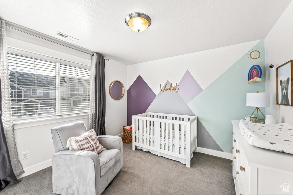 Bedroom featuring carpet floors, baseboards, a crib, and lofted ceiling