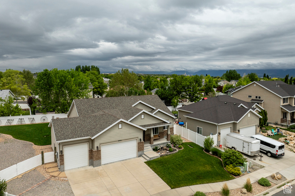 View of front of house featuring an attached garage, brick siding, concrete driveway, a shingled roof, and a residential view