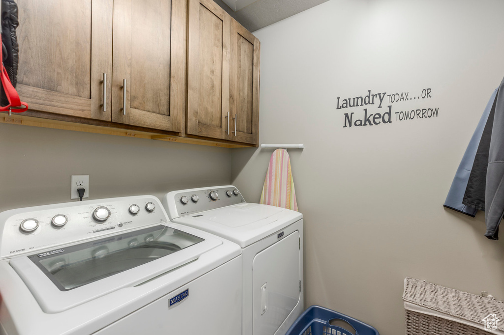 Laundry room featuring independent washer and dryer and cabinet space