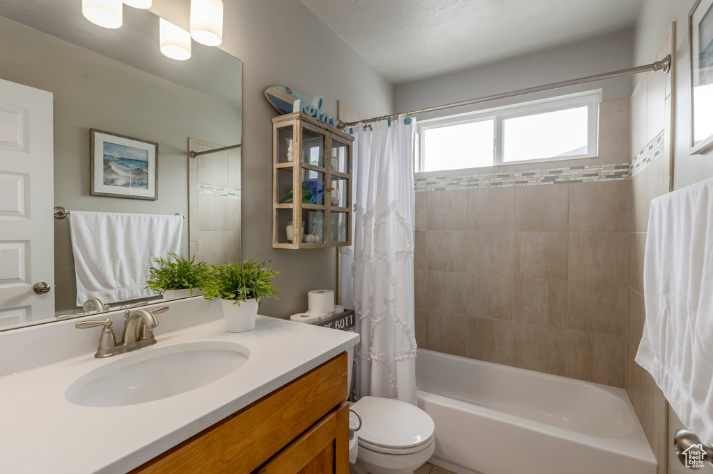 Full bathroom featuring shower / tub combo, toilet, and vanity
