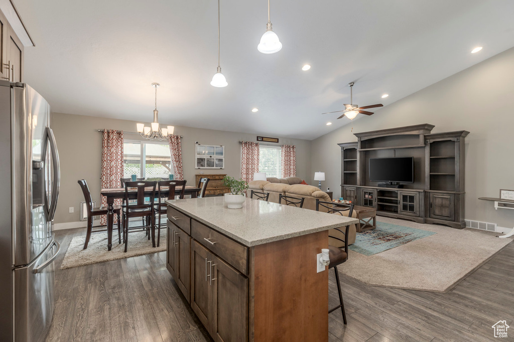 Kitchen featuring stainless steel fridge, a chandelier, healthy amount of natural light, dark wood finished floors, and vaulted ceiling
