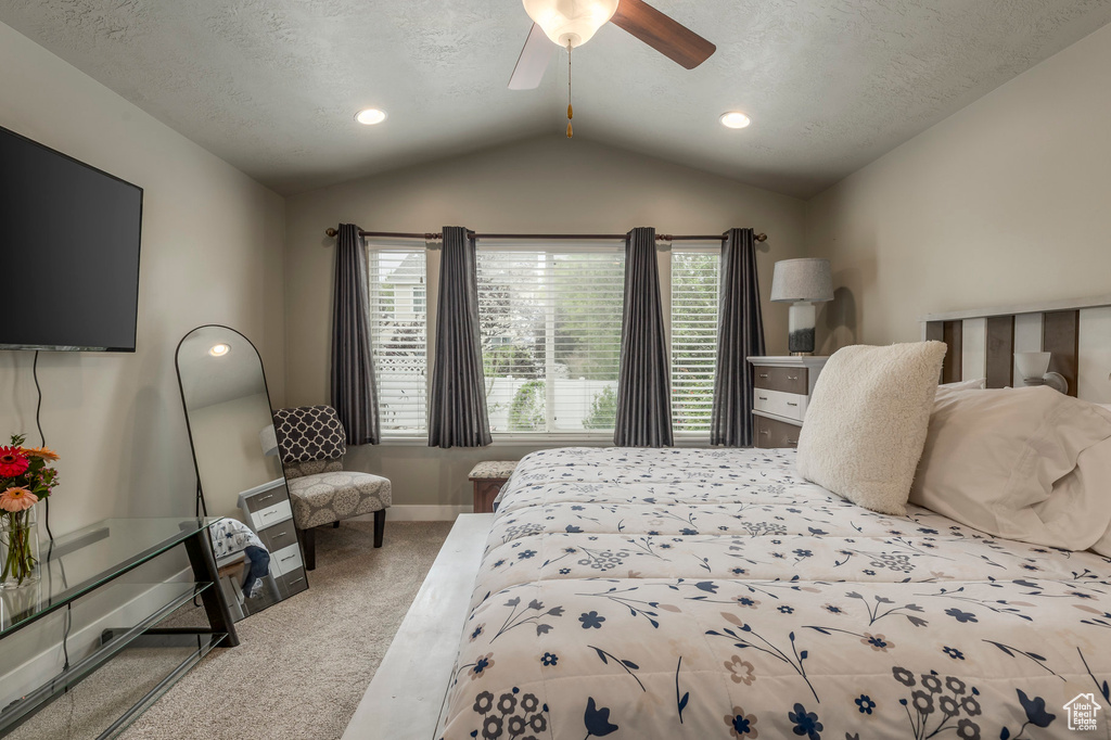 Bedroom with carpet, lofted ceiling, multiple windows, baseboards, and a ceiling fan