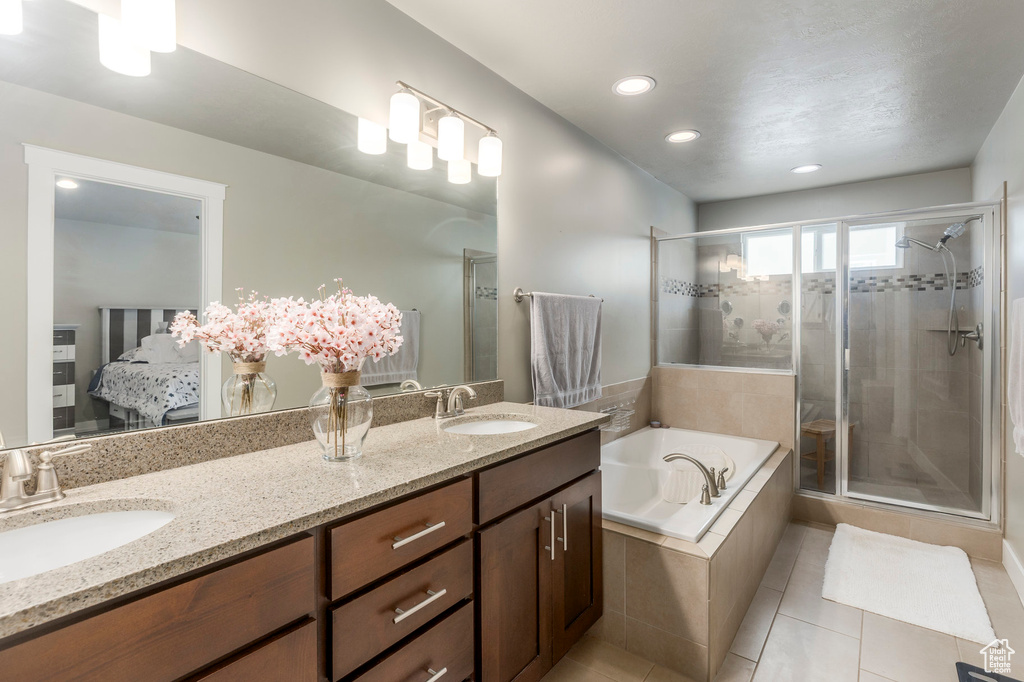 Bathroom featuring a shower stall, a garden tub, tile patterned floors, double vanity, and connected bathroom