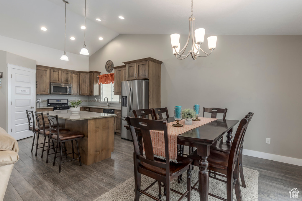 Dining area with a chandelier, vaulted ceiling, dark wood-style floors, recessed lighting, and baseboards