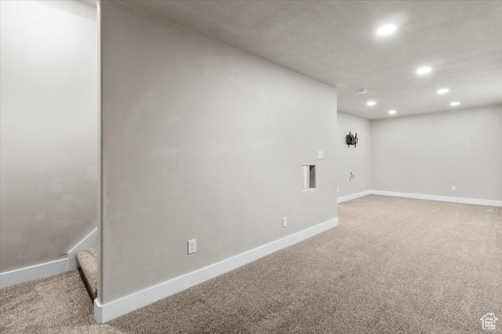 Below grade area with recessed lighting, light colored carpet, and baseboards