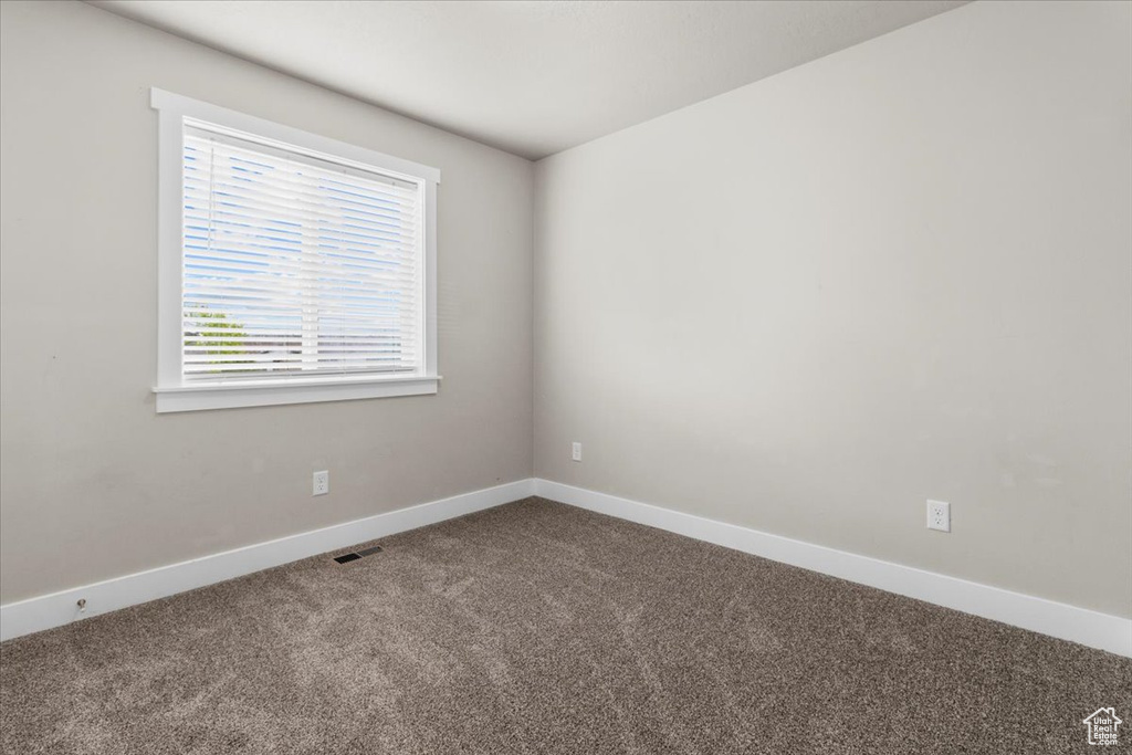 Empty room featuring carpet and baseboards