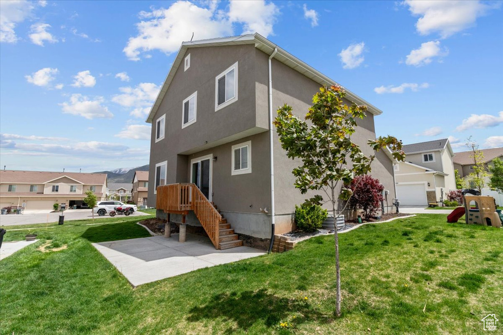 Back of property featuring stucco siding, a residential view, and a yard