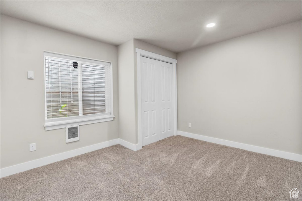 Unfurnished bedroom with carpet, baseboards, a closet, and recessed lighting