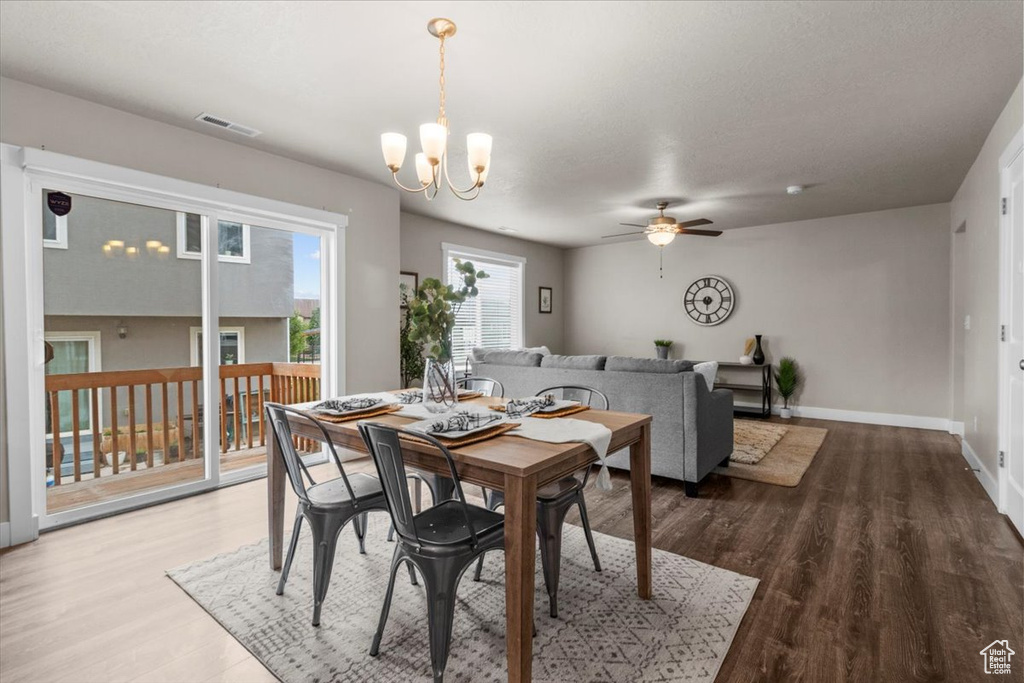 Dining room featuring ceiling fan, a chandelier, wood finished floors, and baseboards