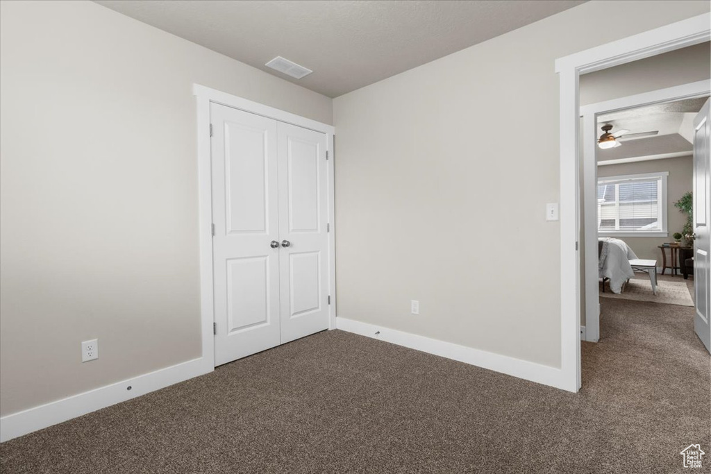 Unfurnished bedroom featuring carpet floors, baseboards, and a closet