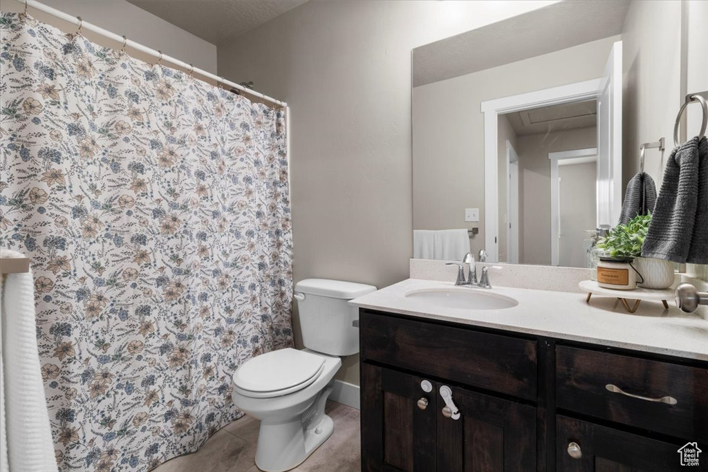 Full bath featuring vanity, toilet, and tile patterned floors