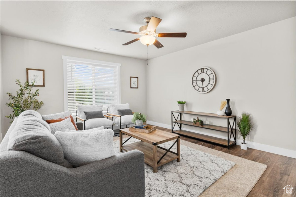 Living area featuring ceiling fan, wood finished floors, and baseboards