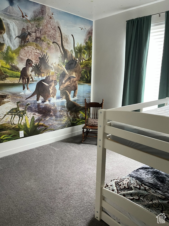 Bedroom featuring carpet and baseboards