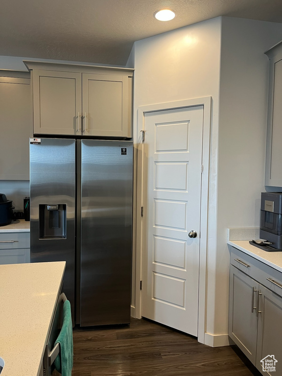 Kitchen with stainless steel fridge with ice dispenser, gray cabinetry, dark wood-type flooring, light countertops, and recessed lighting