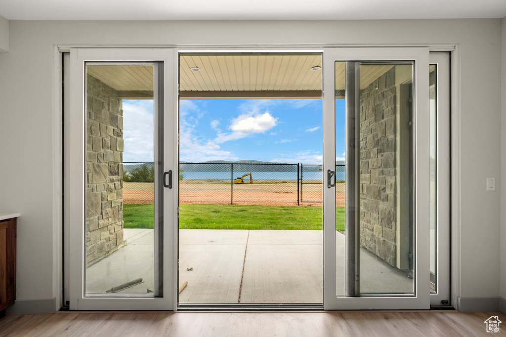Entryway featuring healthy amount of natural light, a water view, and wood finished floors