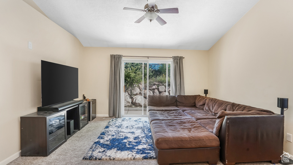 Carpeted living area with baseboards and ceiling fan