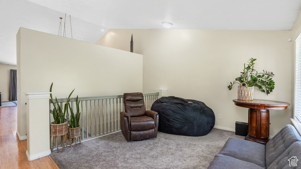 Living room featuring vaulted ceiling, baseboards, and wood finished floors