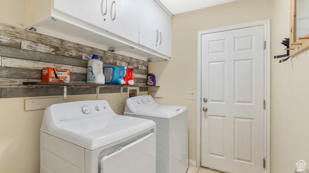 Washroom with washer and clothes dryer and cabinet space