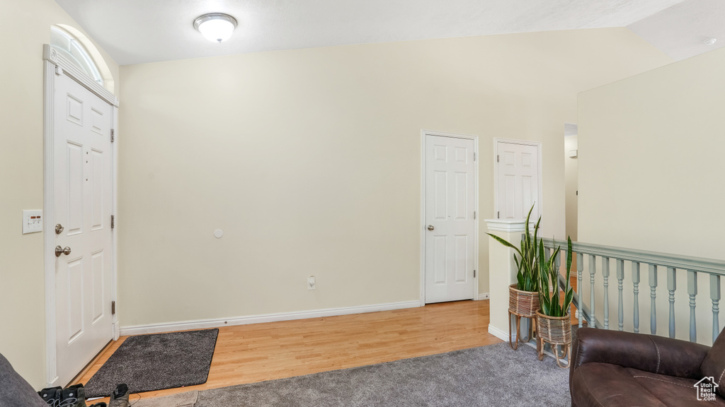 Carpeted foyer entrance featuring wood finished floors and baseboards