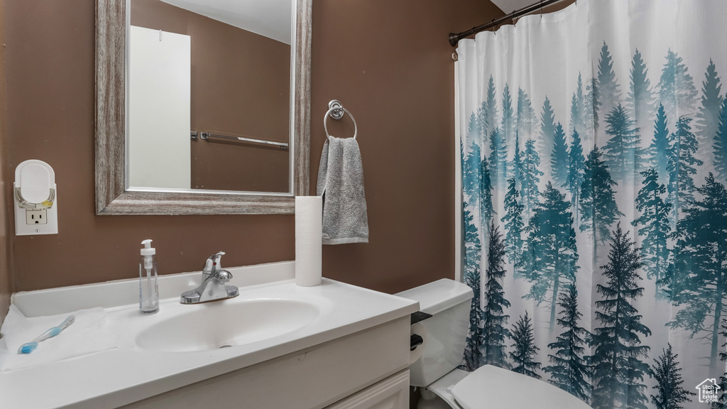 Full bath featuring toilet, vanity, and a shower with shower curtain