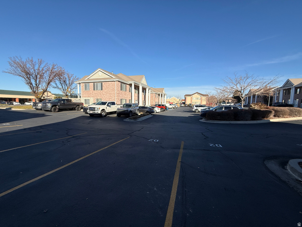 View of asphalt road featuring a residential view and curbs