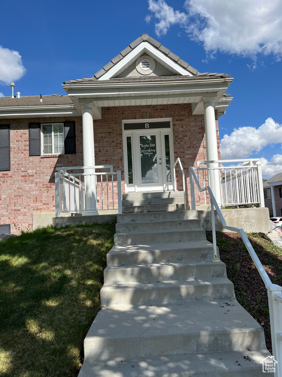 View of front of property featuring brick siding and covered porch