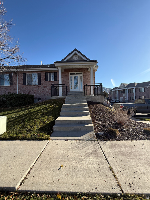 View of front of house featuring brick siding and covered porch
