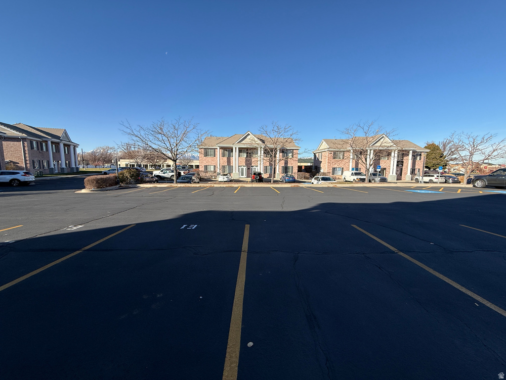 View of asphalt street featuring a residential view and curbs