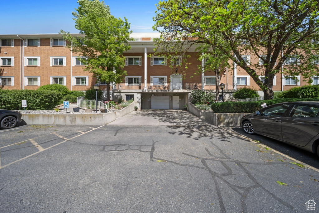 View of building exterior featuring an attached garage and driveway