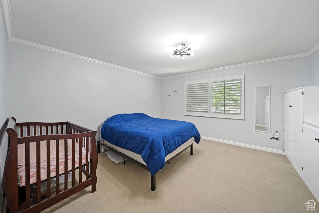Bedroom featuring crown molding, carpet floors, and baseboards