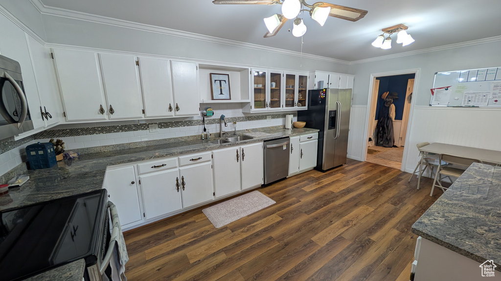Kitchen featuring stainless steel appliances, crown molding, ceiling fan, decorative backsplash, and white cabinets