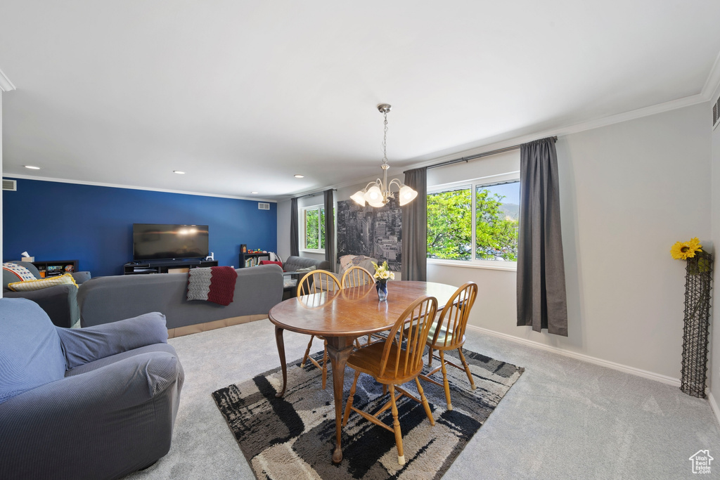 Dining room featuring a chandelier, carpet, crown molding, baseboards, and recessed lighting