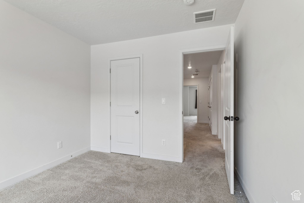 Unfurnished bedroom featuring carpet and baseboards
