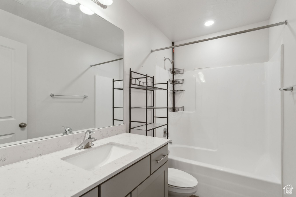 Bathroom with toilet, vanity,  shower combination, and recessed lighting