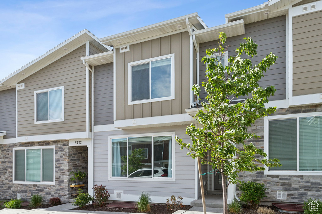 View of front of property with board and batten siding and stone siding