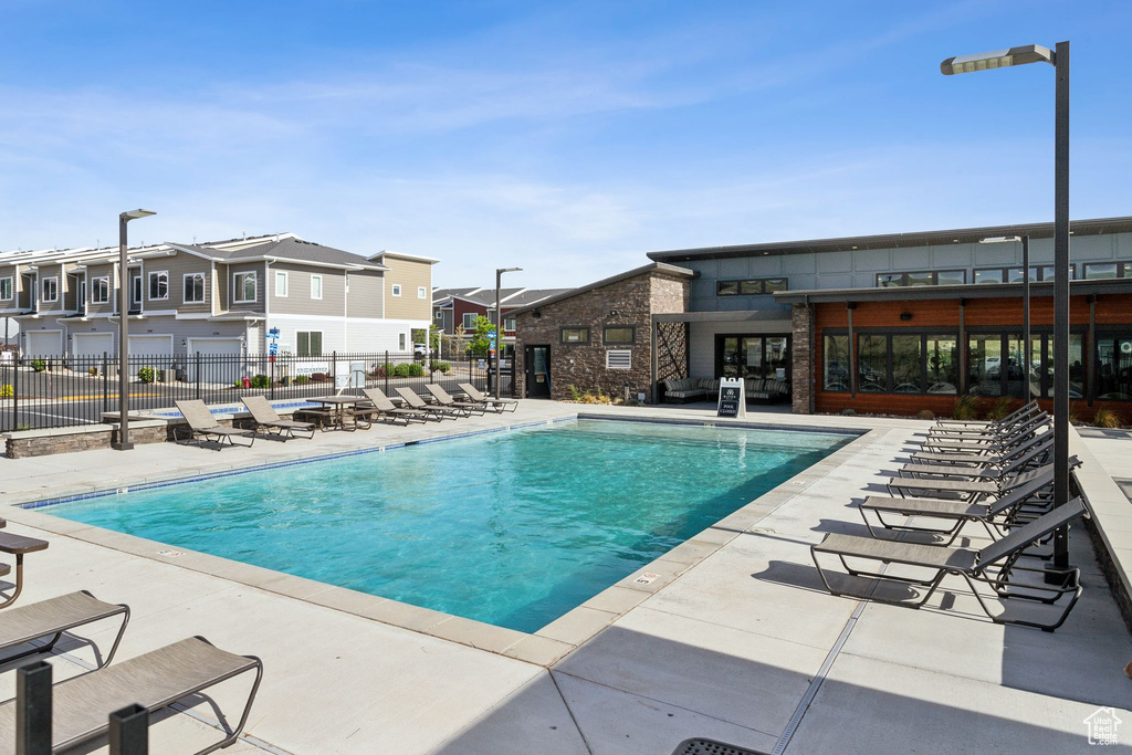 Community pool featuring a residential view, fence, and a patio area
