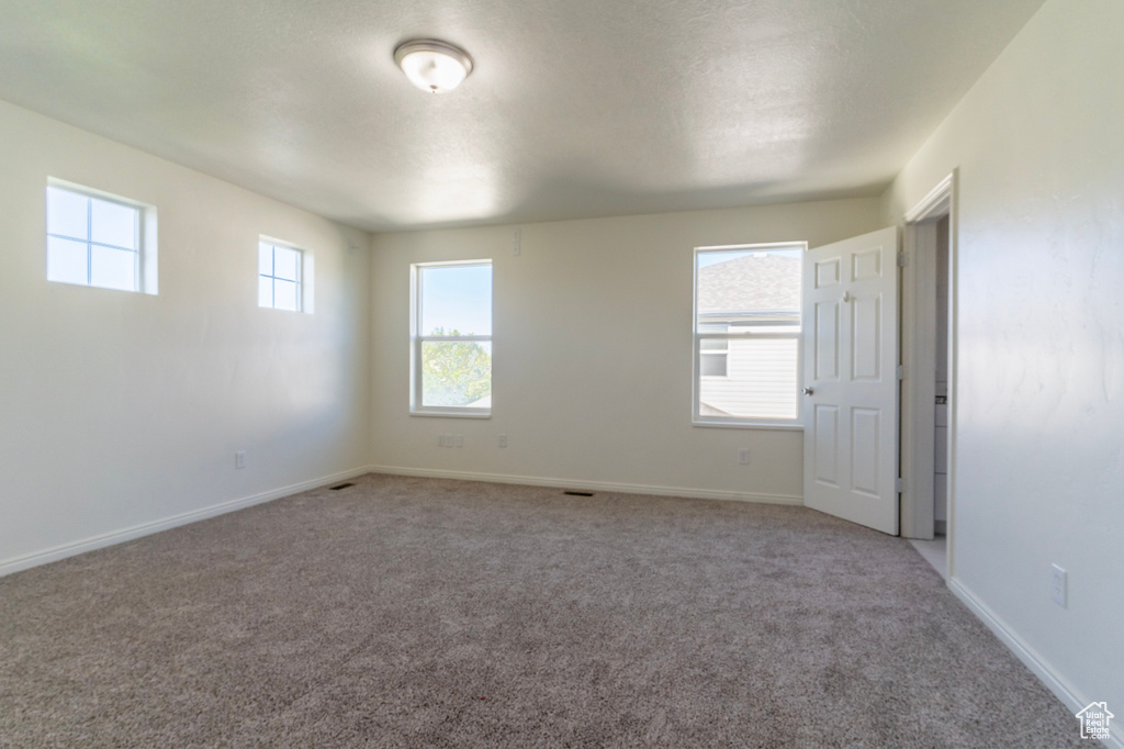 Empty room featuring light carpet and baseboards