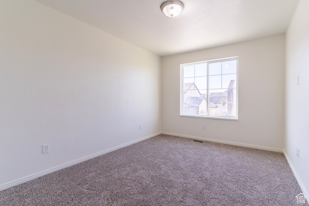 Unfurnished room featuring carpet floors and baseboards