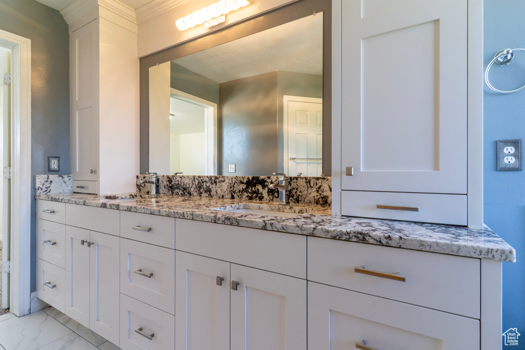 Bathroom with vanity and marble look tile flooring