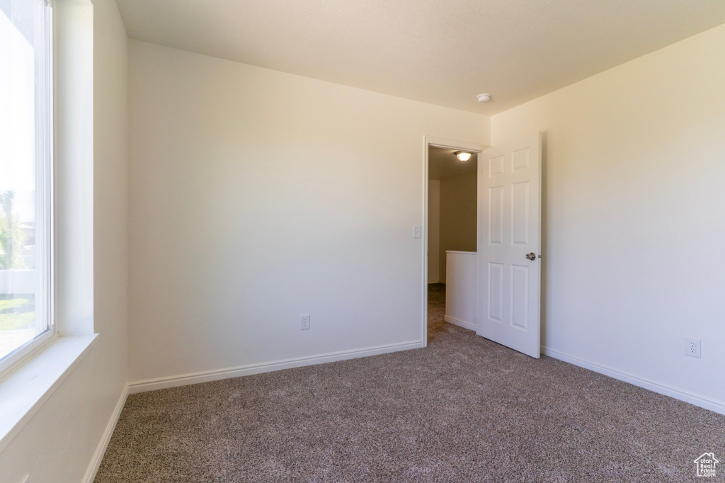 Spare room with carpet, baseboards, and a smoke detector
