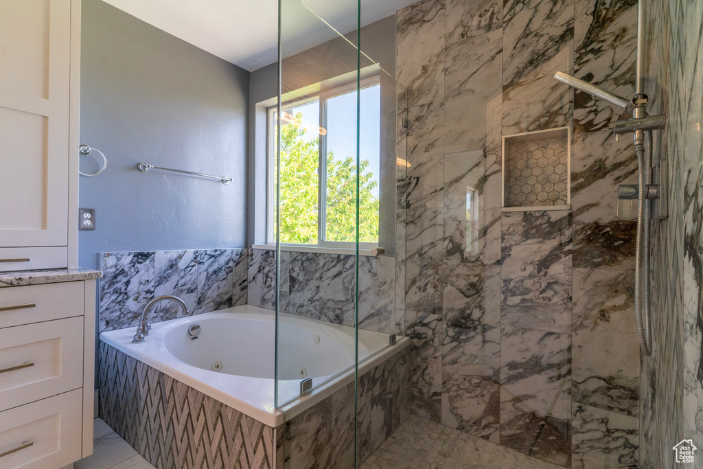 Full bath with a tub with jets and a marble finish shower