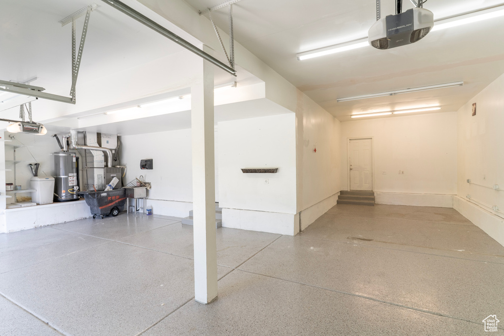 Garage with a garage door opener, gas water heater, and heating unit
