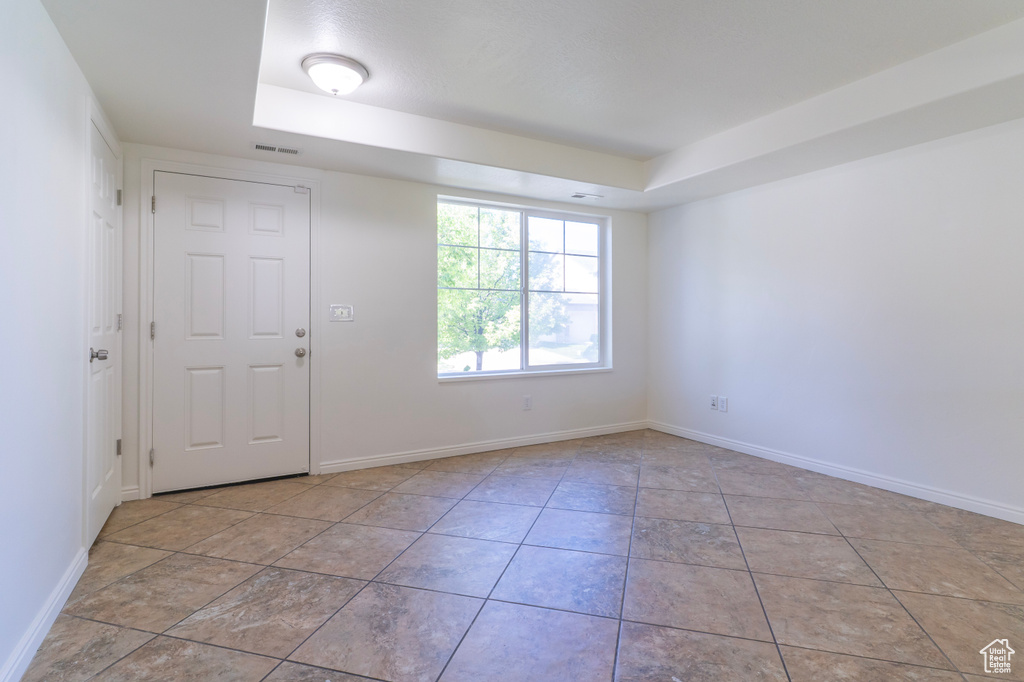 Unfurnished room featuring a tray ceiling and baseboards