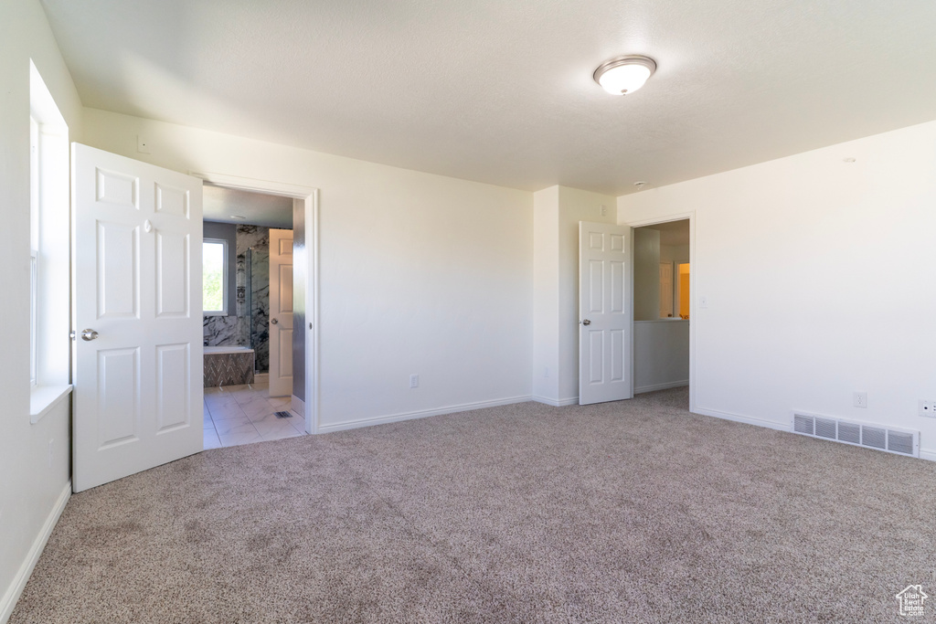 Unfurnished bedroom with carpet flooring, baseboards, and connected bathroom