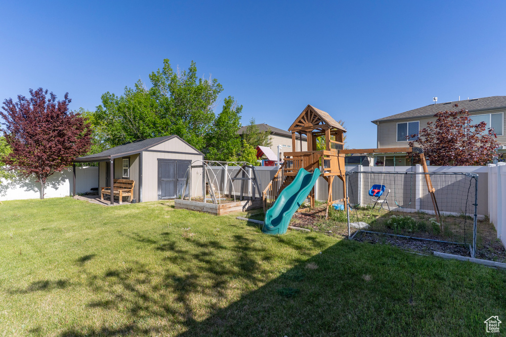 View of playground featuring a shed and an outbuilding