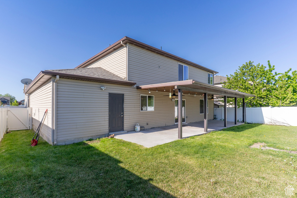 Back of property with a patio, a ceiling fan, a gate, and roof with shingles