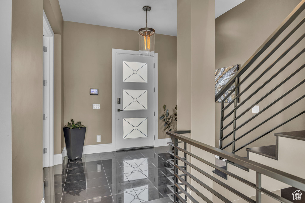 Foyer entrance featuring baseboards, granite tiled floors, and stairs