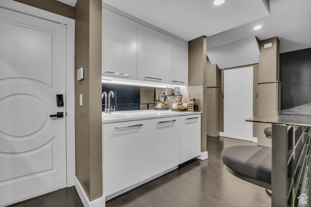 Kitchen with a sink, recessed lighting, light countertops, white cabinetry, and modern cabinets