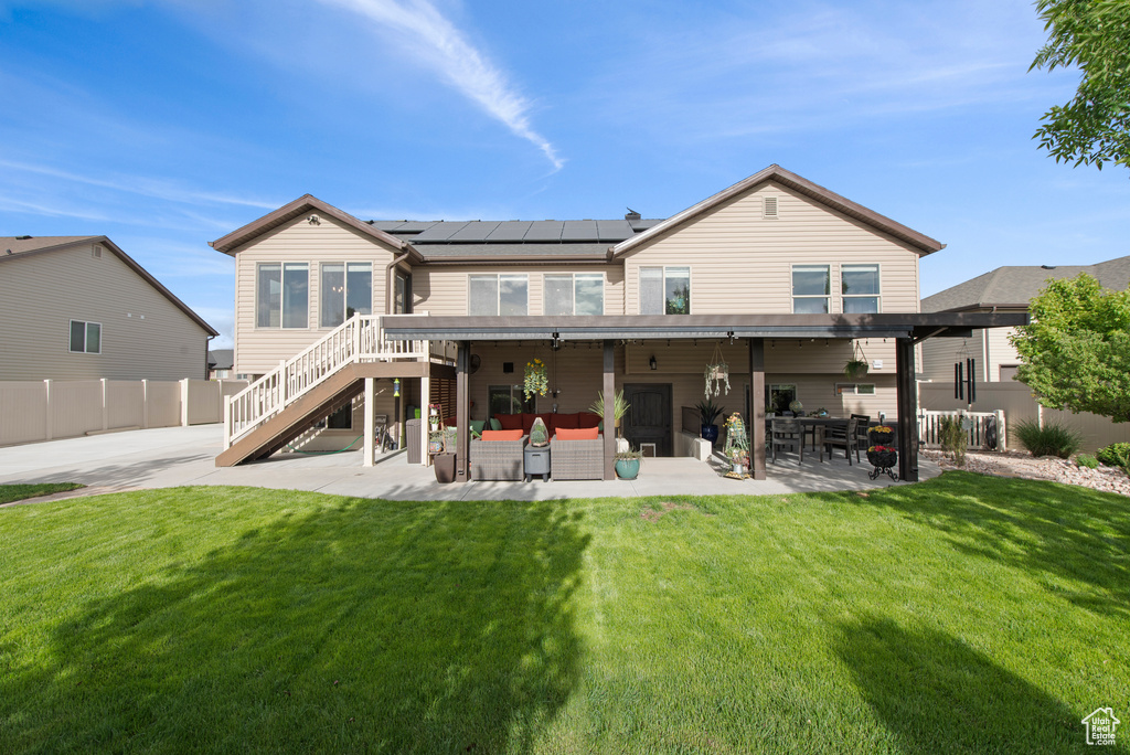 Back of house featuring an outdoor living space, a patio, solar panels, and stairs