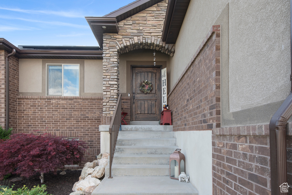 View of exterior entry with stucco siding and brick siding